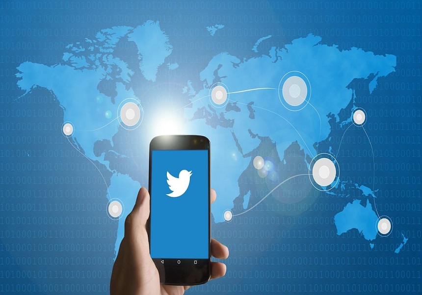 Mapamundi con un móvil donde se ve el logo de Twitter